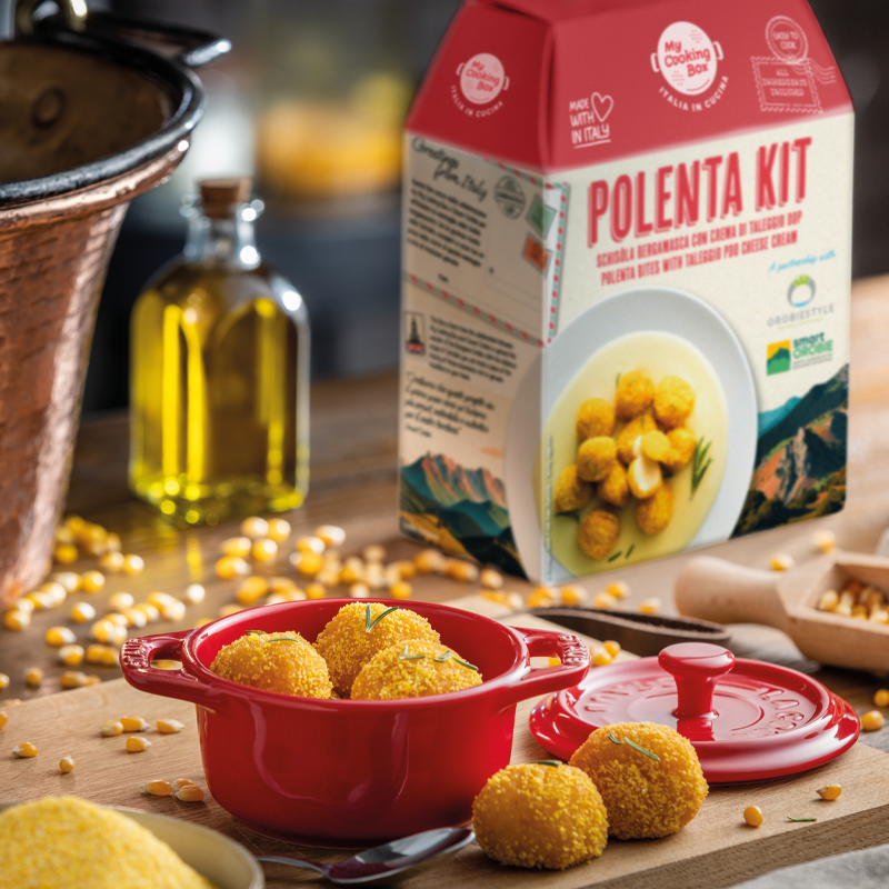 Piatto di polpette di polenta con crema di Taleggio DOP e sullo sfondo il Polenta Kit di My Cooking Box