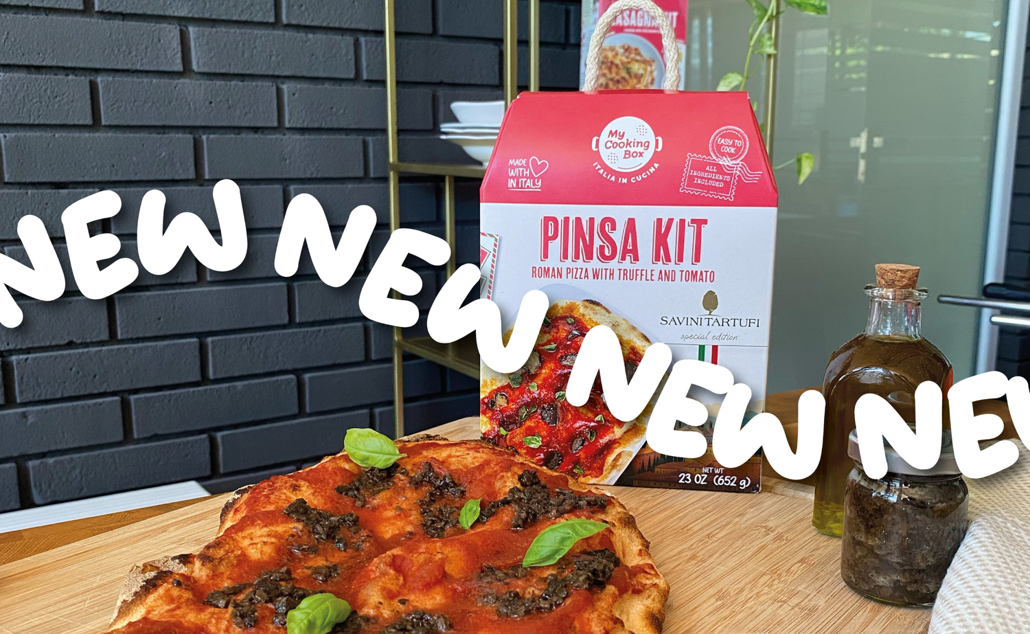 piatto di pinsa con Pinsa Kit sullo sfondo e la scritta NEW che scorre su tutta l'immagine